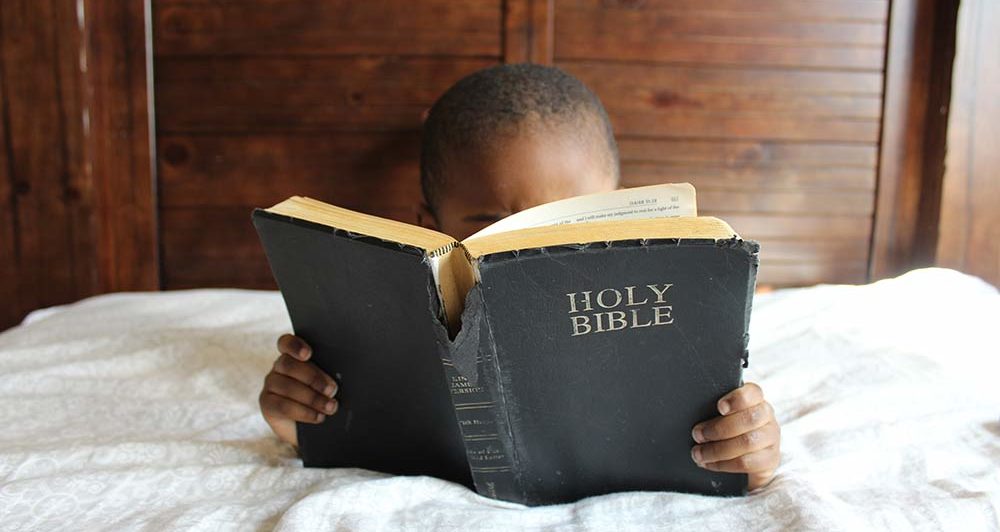 Five year old reading Bible